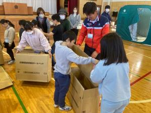協力して段ボールベッドを作成している様子