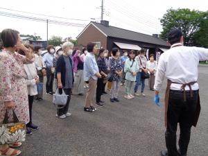 筑波ハム直売所で案内係のかたに説明を受けています