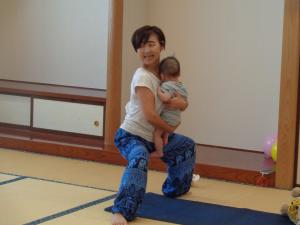 先生が赤ちゃんを抱いてヨガをしている写真です