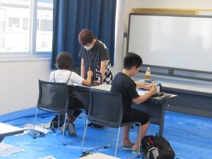 講師が参加者に指導している写真です
