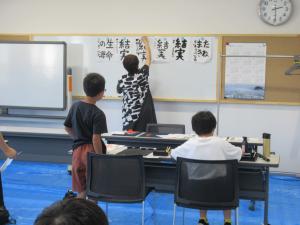 講師が作品をホワイトボードに掲示している写真です