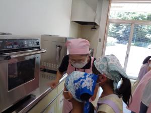 オーブンの中をのぞき込む女の子の写真