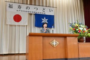 主催者がステージ上で挨拶をしている写真です