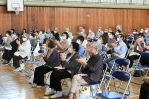 列席者たちが拍手をしている写真です。