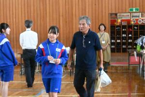 ボランティアの女子中学生が、参加者を案内している写真です。