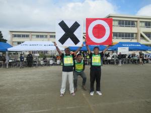 まるばつクイズで使用するパネルをもつ係員の写真です。