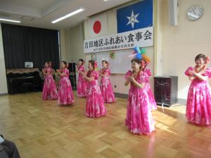 女性たちがフラダンスを踊っている写真です。