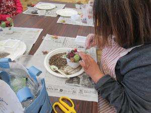 参加者が苗を植え込んでいる写真です。