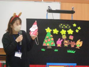 先生がサンタクロースのバック制作の説明をしている写真です