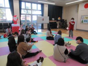 子供を抱っこしてリトミックをしている写真です。