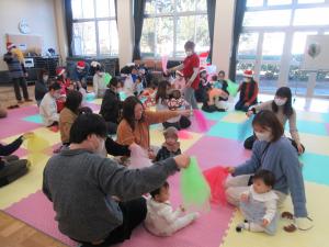 柔らかな布を音楽にあわせてふっている親子の写真です。