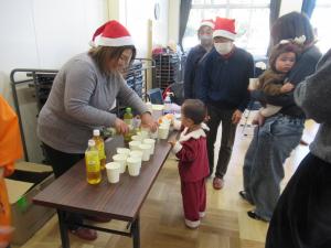 スタッフが参加者に飲み物を渡している写真です。