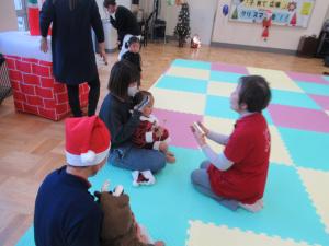 先生と親子が楽器を鳴らしている写真です。