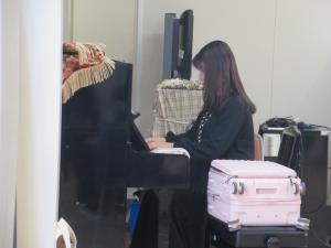 伴奏の増渕先生がピアノを弾いている写真です。