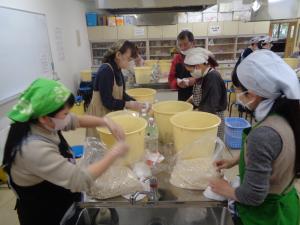 参加者が樽に味噌の材料を入れている