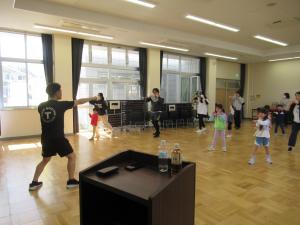 講師と参加者が音楽にあわせてパンチをしている写真です。