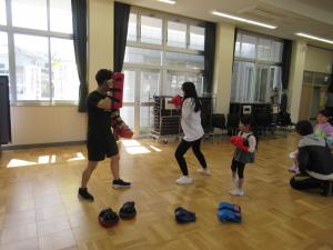 お母さんがミット打ちをしている写真です。