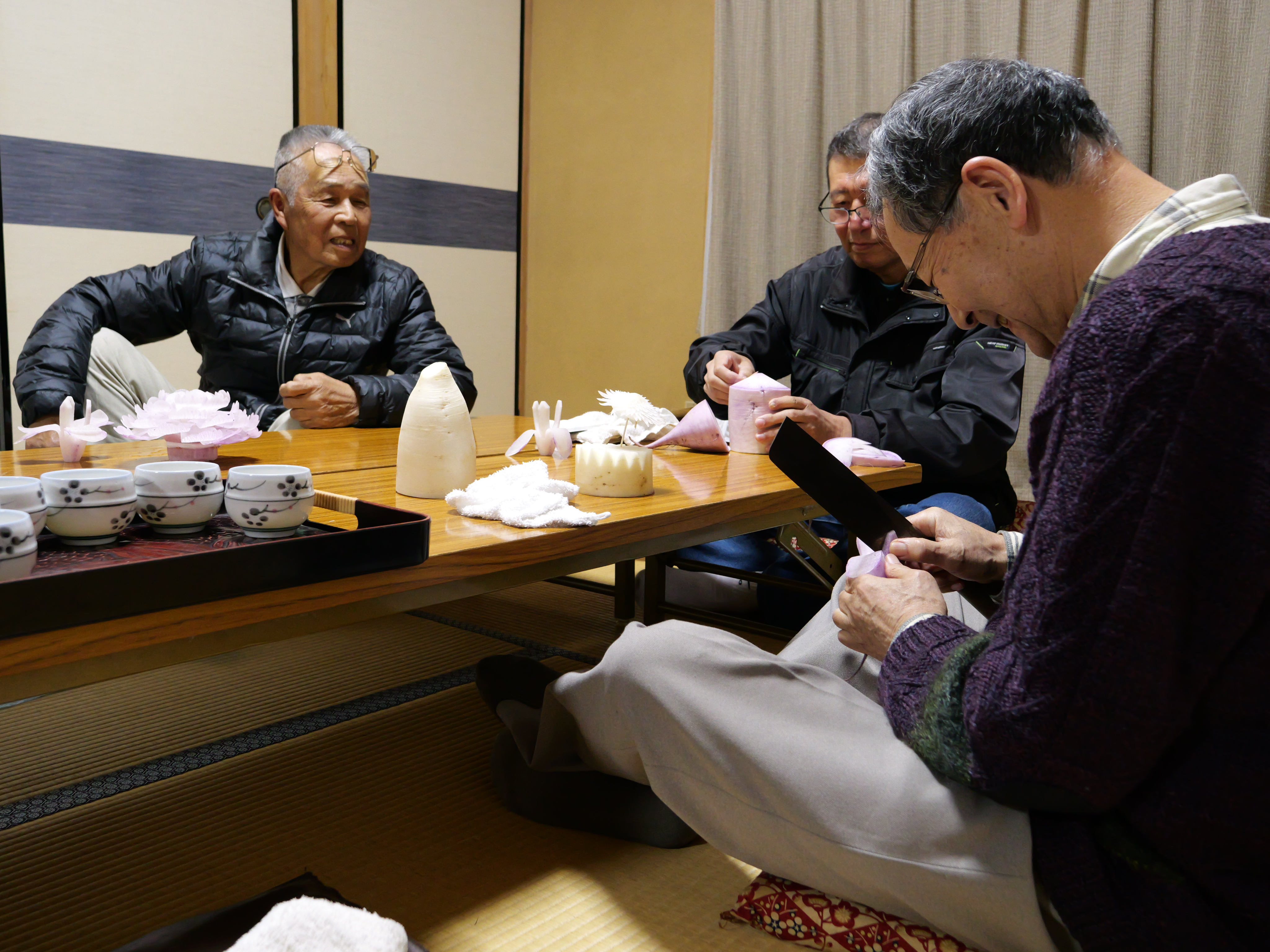 大根むき花保存会の皆さんがそれぞれ大根むき花に取り組んでいる