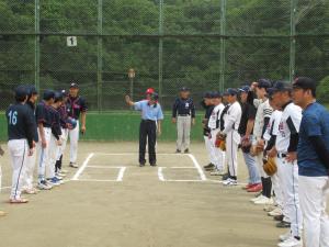 グラウンドで向かい合って整列した2チームの選手に、審判が説明を行っている写真