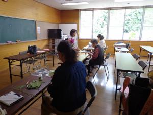 受講生たちに講師が指導をしている写真です。