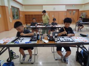 丁寧に書く3年生と指導する先生