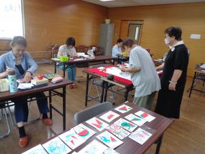 受講生たちが絵手紙をかいている写真です。
