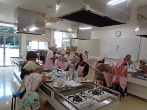 みんなで出来上がった料理を食べている写真