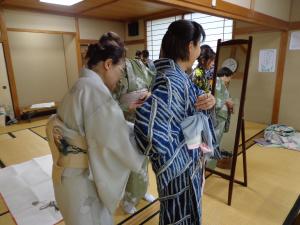 講師が帯のしめ方を教えている写真です。