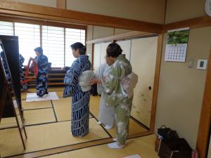 講師が帯のしめ方を教えている写真です。