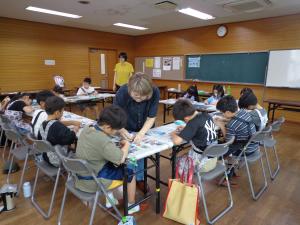 講師が小学生に教えている写真です