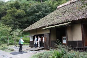 水戸光圀が隠居していた家の復元の前でガイドさんが説明している