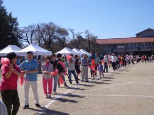 地区の人たちが火の国音頭を踊っている写真です。